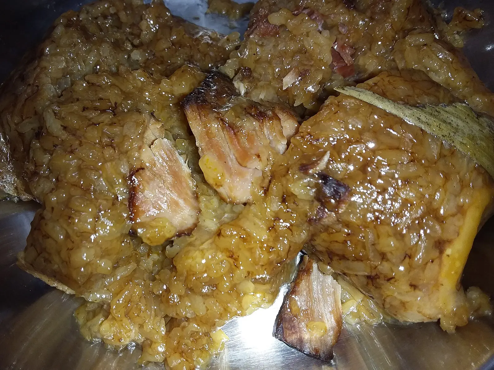 A peeled Jiaxing-style soy-sauce pork zongzi showing the soy-darkened glutinous rice and pork; made by a Hong Kong food company and photographed in Hong Kong, not in Jiaxing