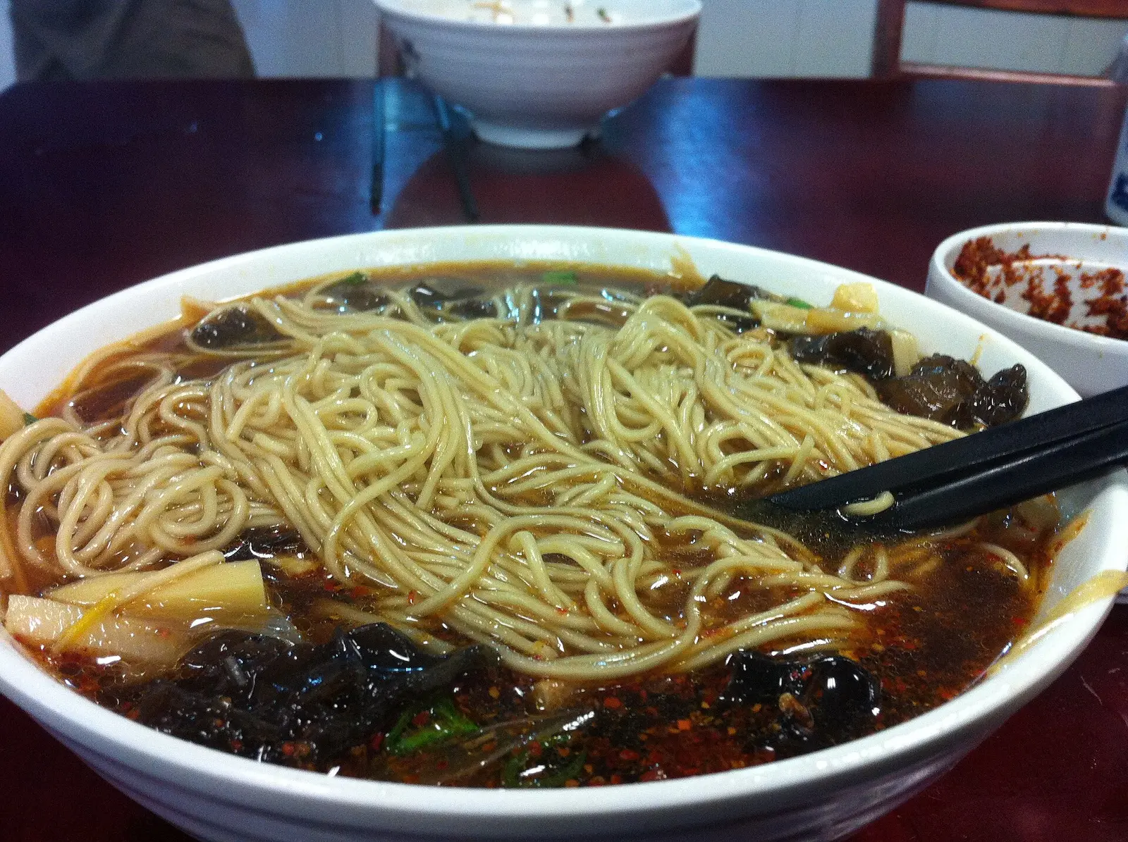 A bowl of Su-style noodle soup topped with braised shiitake mushrooms (location of the photo not stated)