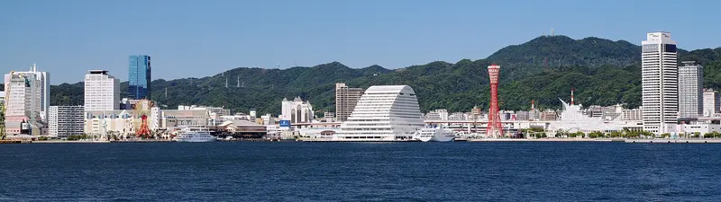Panorama del puerto de Kobe y la torre roja del puerto, vistos al otro lado del agua desde el parque Po-ai Shiosai
