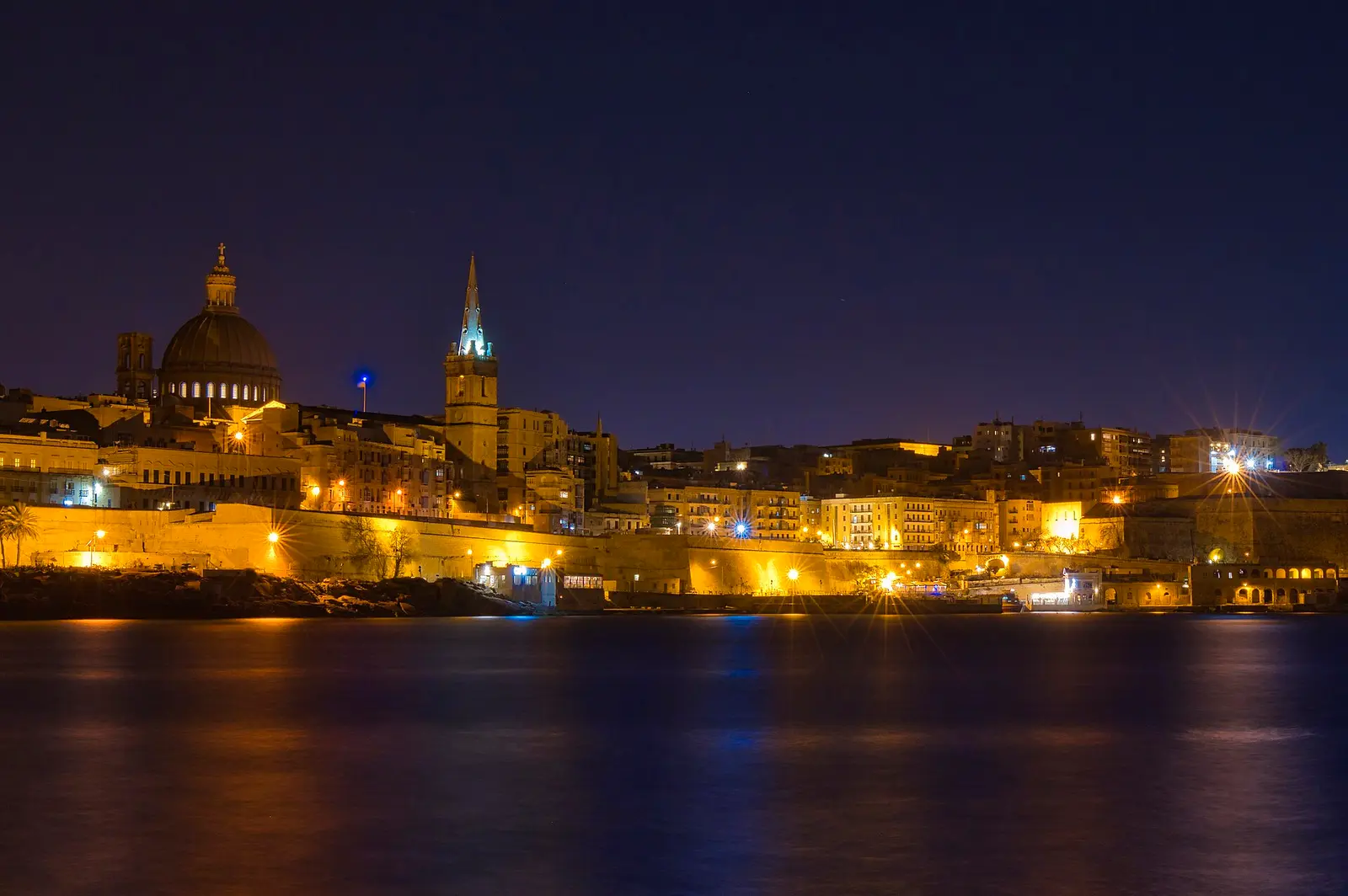 El perfil de La Valeta fotografiado de noche en 2020, que muestra la silueta de la ciudad desde el lado del puerto; no significa que los lugares de interés abran de noche