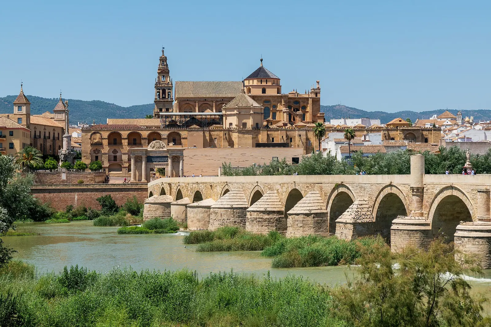 Córdoba's historic centre photographed from the bank of the Guadalquivir in 2023, showing the Mosque-Cathedral and the Roman Bridge
